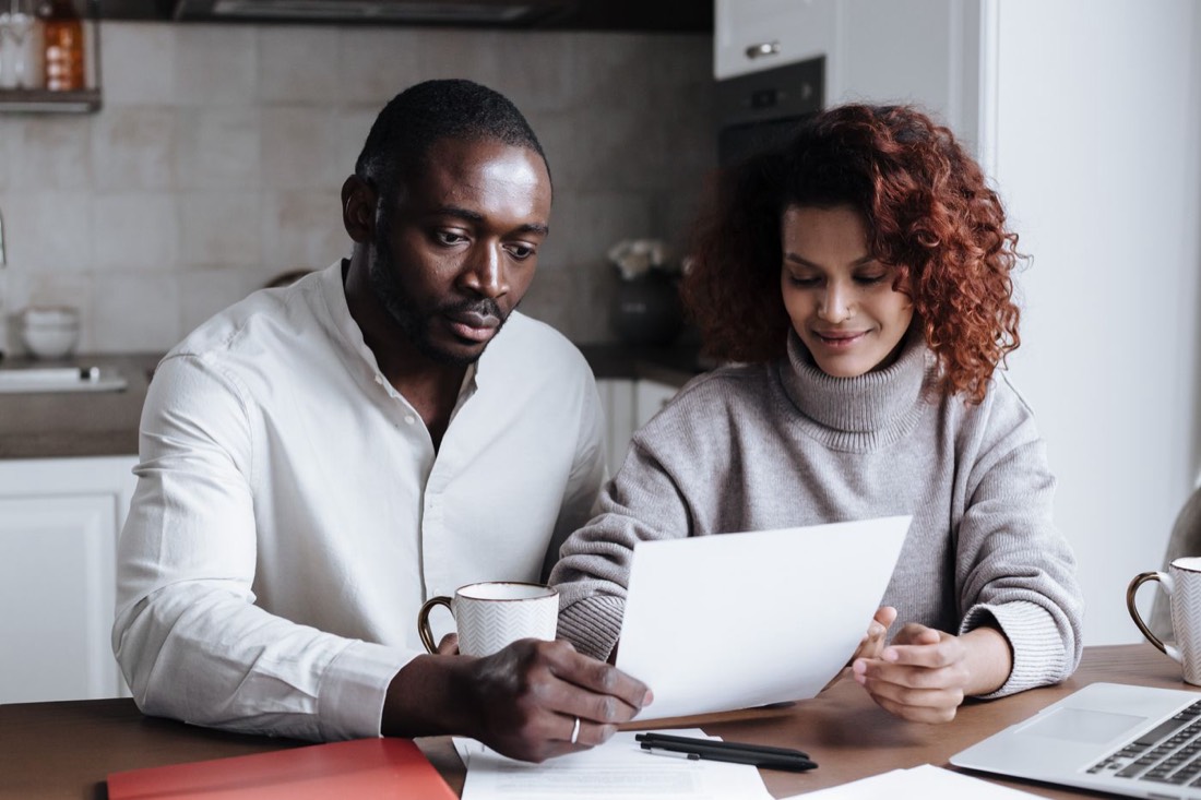 A couple going over paperwork at the kitchen table