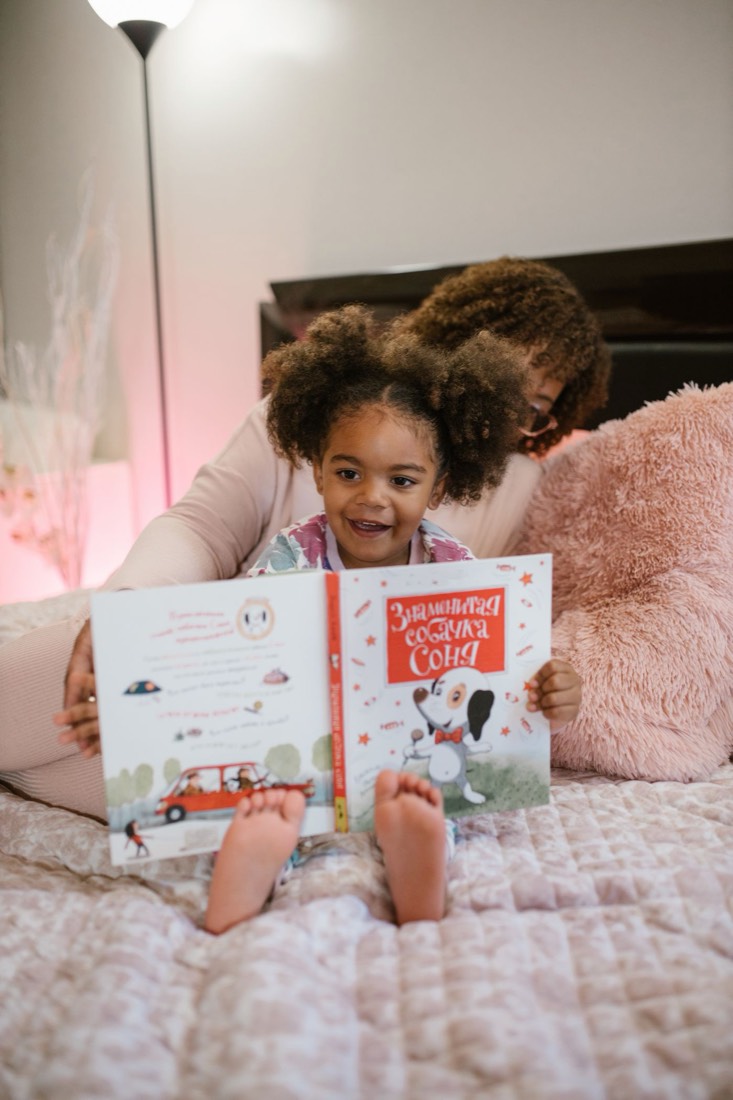A mother and daughter reading a colorful picture book